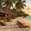 Beachfront resort cottages on a white sand Havelock beach at golden hour, Andaman Islands