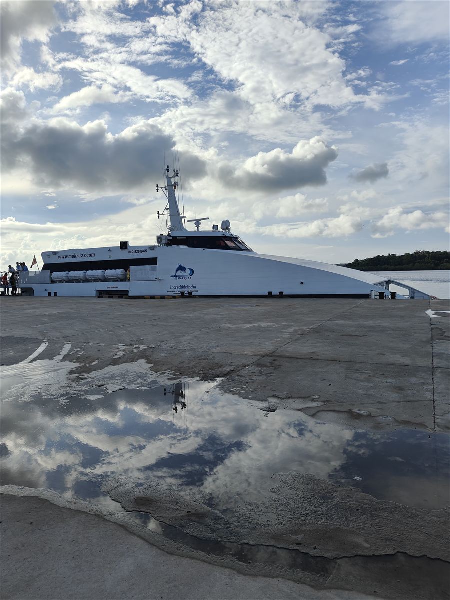 Side profile of the Makruzz catamaran at the jetty, with cloud reflections, on the new Baratang route